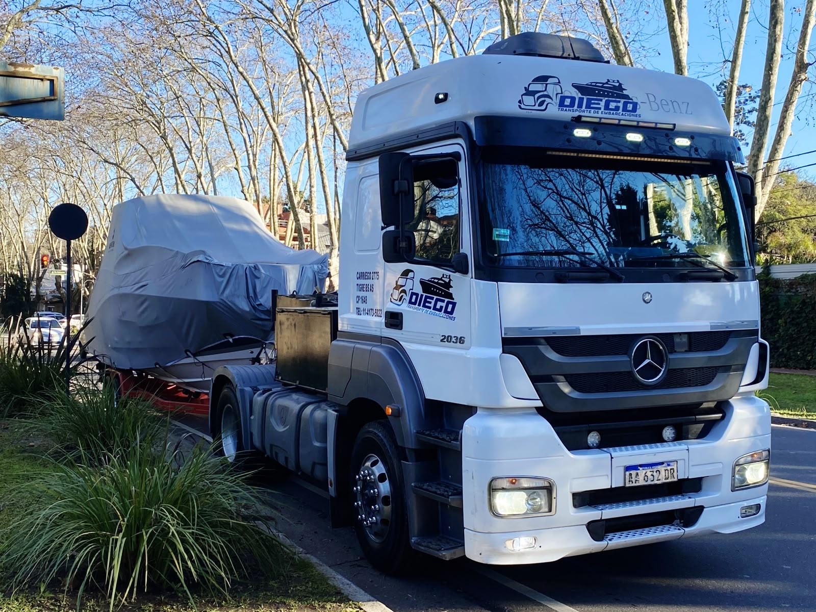 Mercedes-Benz Axor con una lancha cubierta con lona